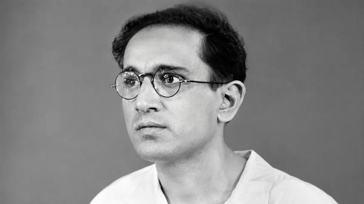Studio portrait of Batukeshwar Dutt as a young man, wearing round wire-framed spectacles and a white kurta.