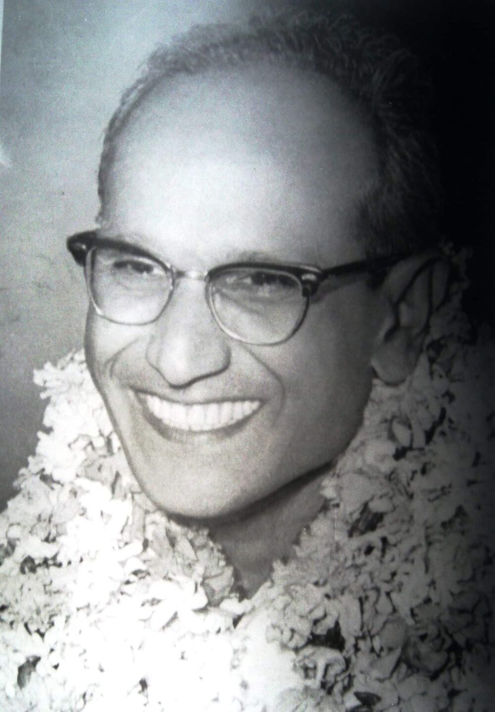 Portrait of Batukeshwar Dutt in later life, garlanded, wearing spectacles.